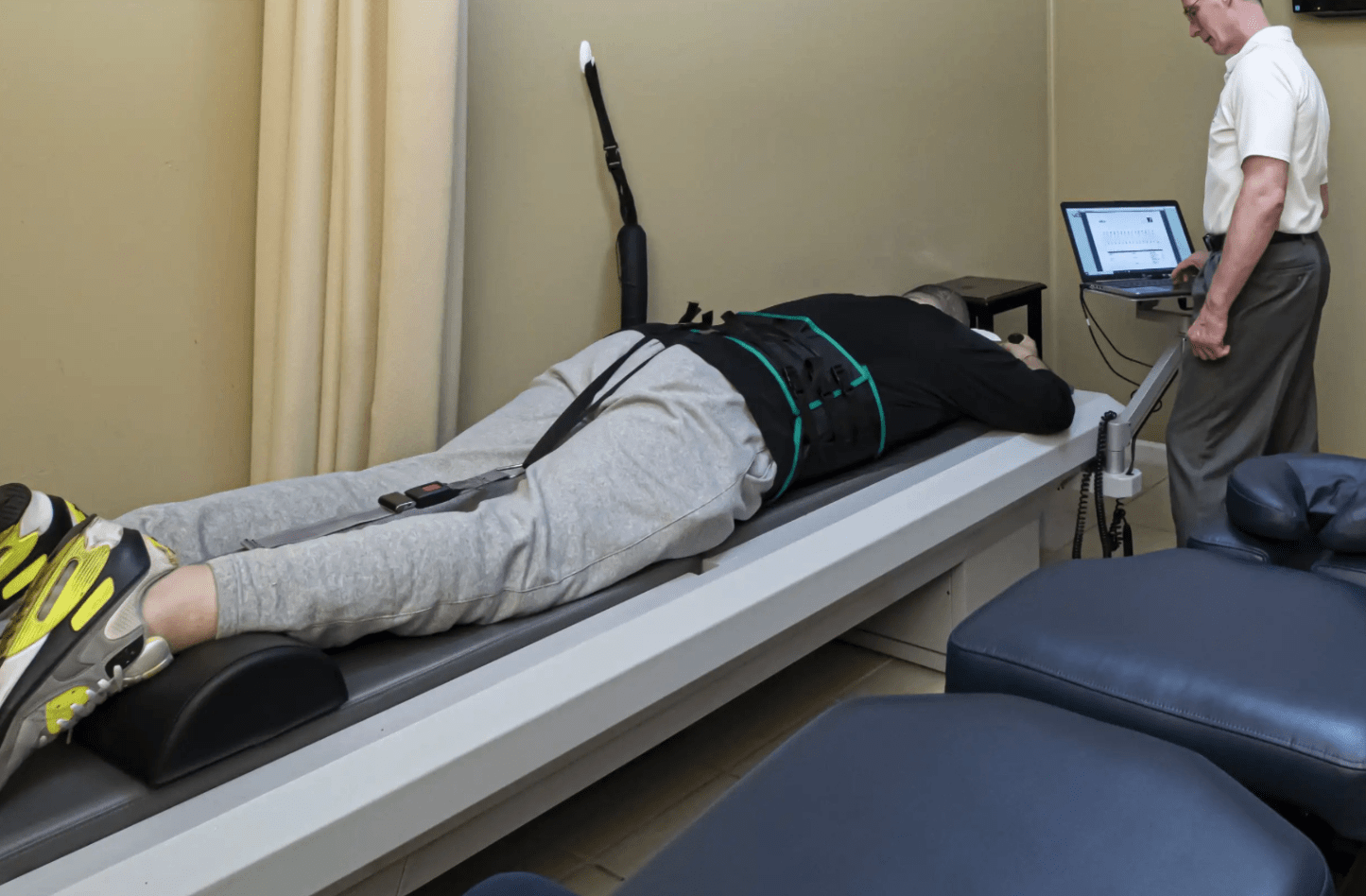 Patient receiving vertebral axial decompression therapy on a VAX-D table for car accident back injury relief